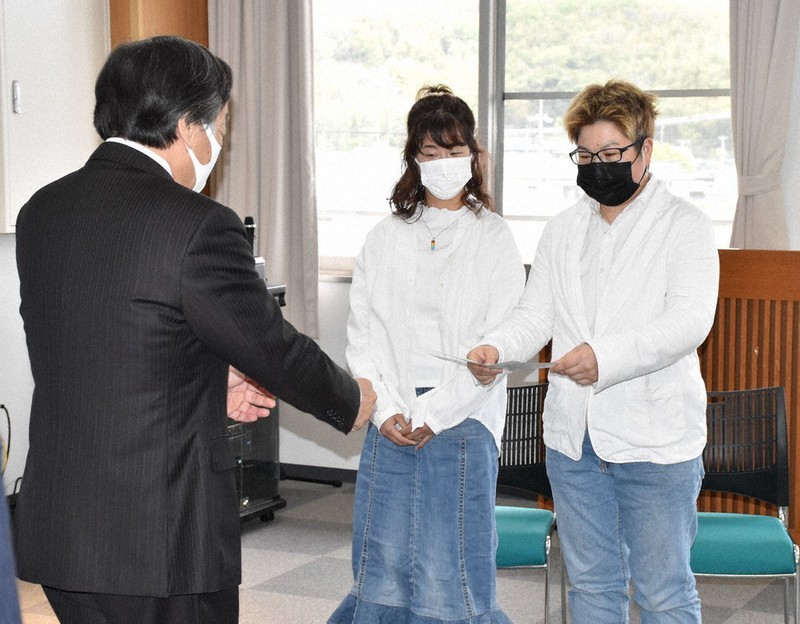 小豆島町役場で松本篤町長(左)に宣誓書を手渡す高橋瑞佳さん(右)とパートナーの女性=香川県小豆島町で2021年4月14日午後1時28分、西本紗保美撮影