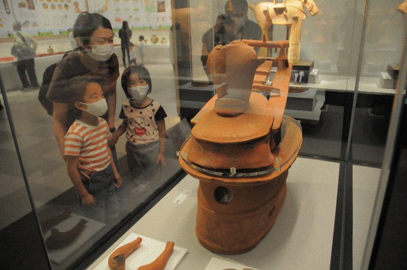 機織り姿の埴輪に見入る親子=栃木県下野市国分寺のしもつけ風土記の丘資料館で2021年5月2日、竹田直人撮影