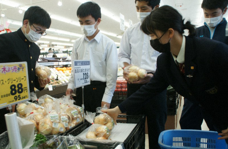 有機栽培したタマネギを店頭に陳列する生徒たち