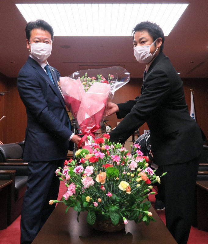 カーネーションの花束を受け取る大久保市長(左)