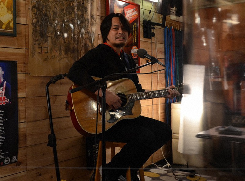 リハーサル中に笑顔を見せるシンガー・ソングライターの聞間拓さん=横浜市中区の音楽酒場SARASVATHI弁天で