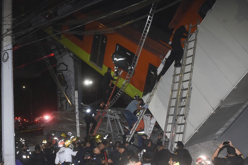 地下鉄の高架線路崩落事故現場で遺体を収容する消防士ら=メキシコ市で2021年5月3日、AP