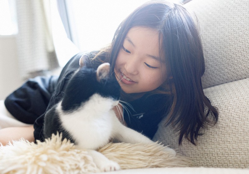 自宅で保護猫の「すーさん」と触れ合う岩井凛佳さん=東京都渋谷区で2021年5月3日、吉田航太撮影
