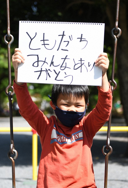 公園で「ともだちみんなありがとう」と書いたスケッチブックを掲げる小学2年の荒井友佑さん=東京都武蔵野市で2021年5月1日、竹内紀臣撮影