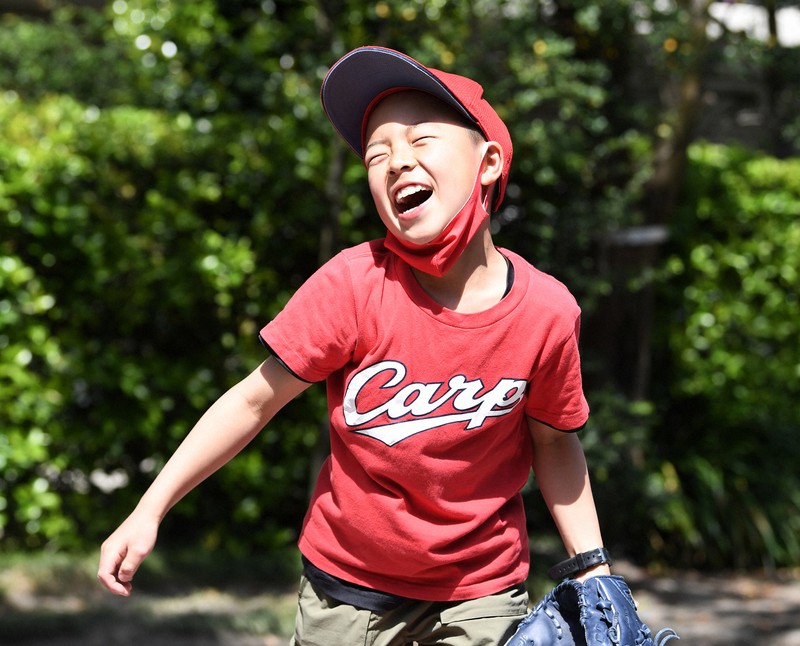 友達とキャッチボールし、笑顔を見せる小学4年の菅悠太郎さん=東京都武蔵野市で2021年5月1日、竹内紀臣撮影
