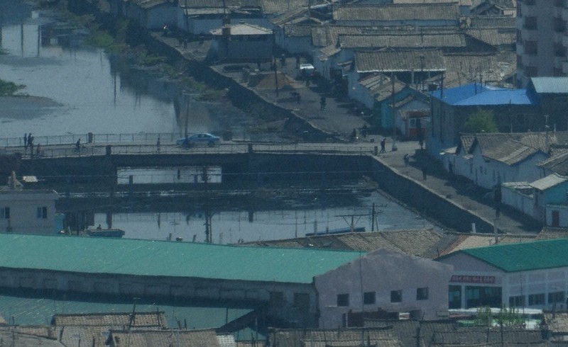 国境封鎖で物資不足が伝えられる北朝鮮北部・新義州。ガソリン不足も伝えられるが、ときおりバスやタクシーが走っていた=対岸の中国遼寧省丹東から2021年5月2日、米村耕一撮影