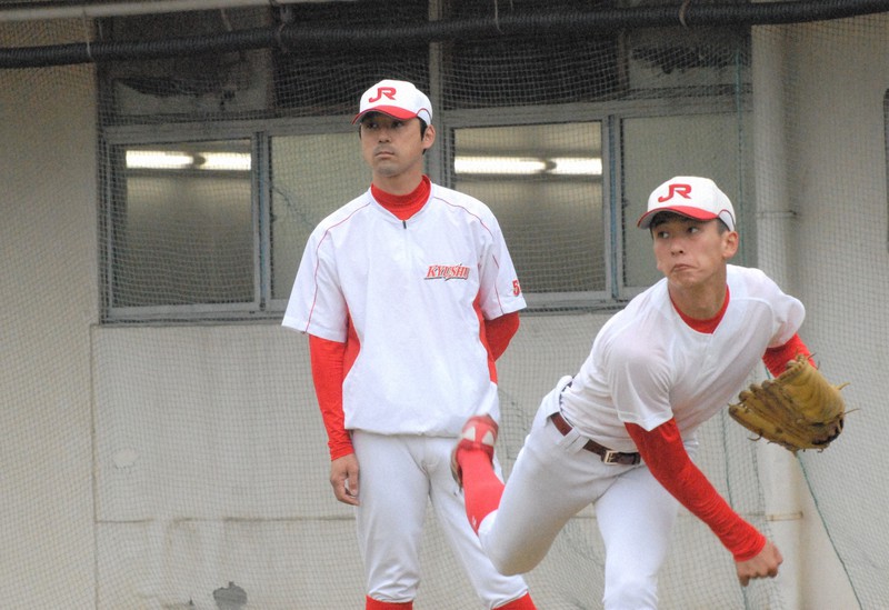 新人右腕・前野将輝(右)のキャッチボールを見つめるJR九州の浜野コーチ=北九州市のJR九州グラウンドで2021年3月16日午後3時3分、吉見裕都撮影