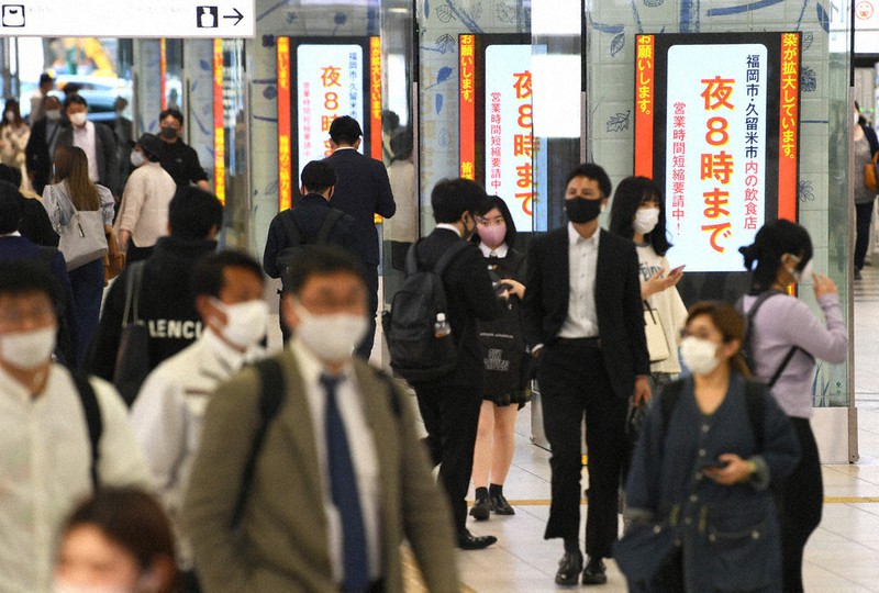 営業時間の短縮要請の掲示がされる中、駅を行き交う人たち=福岡市博多区のJR博多駅で2021年5月6日午後6時16分、矢頭智剛撮影