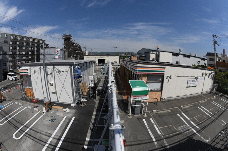 「セブン-イレブン東大阪南上小阪店」の既存店(右)と駐車場に建設が進む仮設店舗(魚眼レンズ使用)