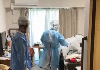 高齢者施設の部屋で新型コロナウイルス患者の治療を行う渡辺克哉医師(中央)ら=2021年4月10日(医療法人社団日翔会提供、画像の一部を加工しています)