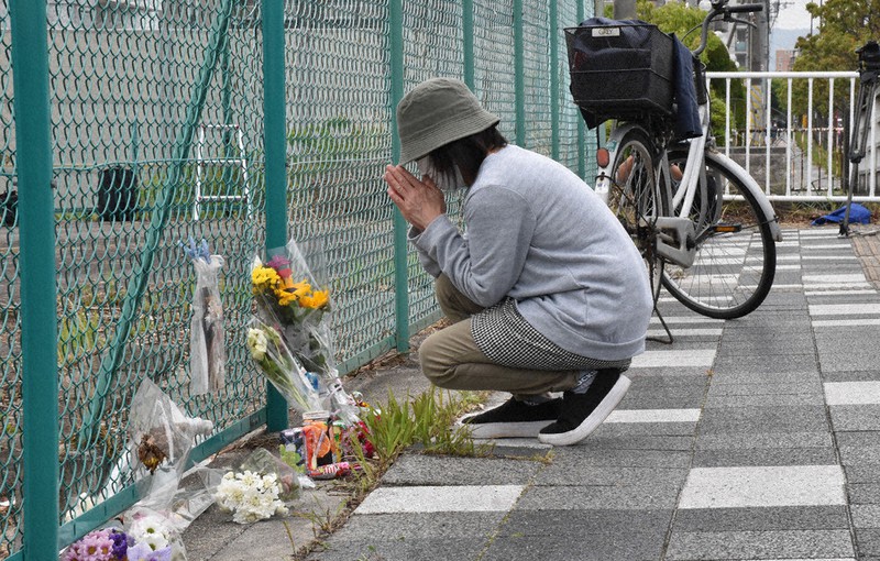 事故現場に献花し、手を合わせる女性=大津市大萱6で2021年5月8日午前10時44分、菅健吾撮影