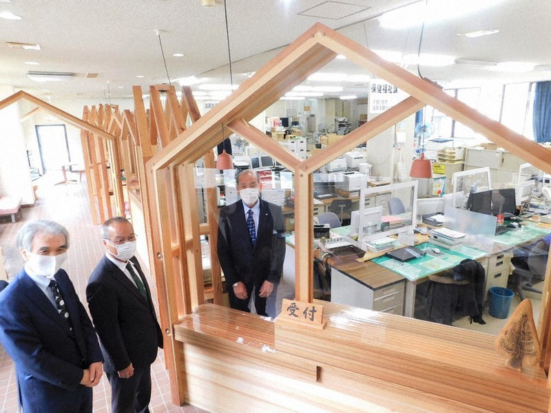 吉野杉を使った家の形の木枠に透明アクリル板をはめ込んだ窓口を披露する辻村源四郎村長(中央)=黒滝村役場で