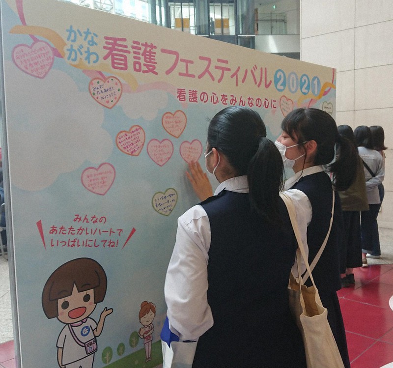 看護師へのメッセージを書いた紙をボードに貼る来場者=横浜市西区で2021年5月8日、宮島麻実撮影