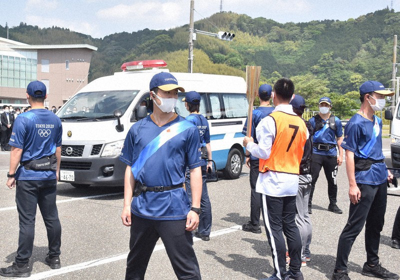 緊急車両(中央奥)が通過した際の警備の態勢などを確認する県警職員ら=静岡市葵区で2021年5月9日、金子昇太撮影
