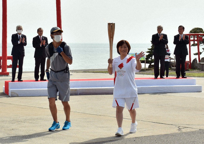 聖火が点火されたトーチを手に出発した坂口さん(右から3人目)