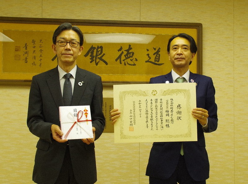 感謝状を受け取った埼玉りそな銀行の福岡聡社長(右)と県社会福祉協議会の山口宏樹会長=さいたま市浦和区の埼玉りそな銀行本店で2021年4月20日、山越峰一郎撮影