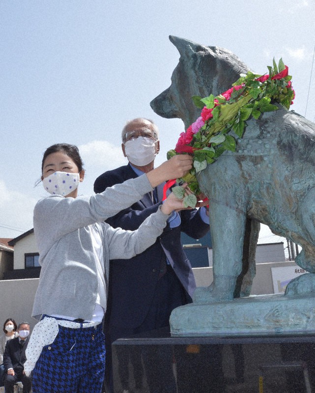 ハチ公銅像に献花する斎藤良作さん(右)と小林紅羽さん=秋田県大館市の秋田犬の里で2021年5月8日、田村彦志撮影