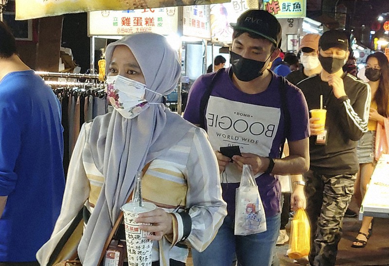 マスクを着用して夜市に出かける人たち=台北で14日、AP