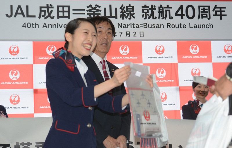 乗客に記念品を配った釜山線の就航40周年の式典=成田空港で2019年7月2日午前10時33分、中村宰和撮影