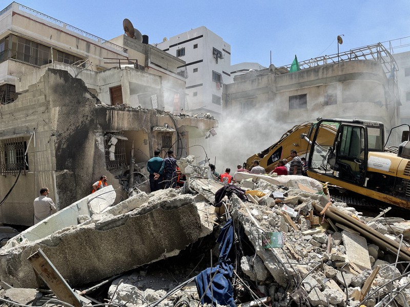 イスラエル軍の空爆で住宅が倒壊し、がれきの中で生存者を探す消防隊員ら=パレスチナ自治区ガザ地区ガザ市で2021年5月16日午後0時55分、三木幸治撮影