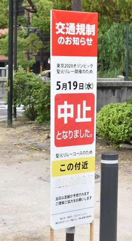 聖火リレーに伴う交通規制を伝える看板に「中止」の張り紙がされていた=岡山市北区柳町で、戸田紗友莉撮影