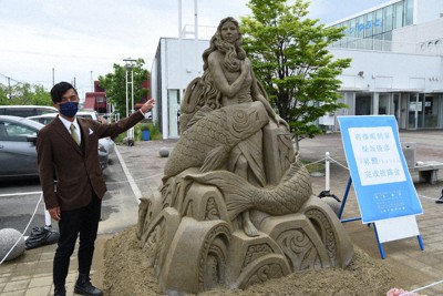 完成した砂像彫刻作品「昇鯉（しょうり）」と制作者の保坂俊彦さん＝宮城県東松島市の矢本駅前広場で２０２１年５月１７日午前１１時２３分、百武信幸撮影