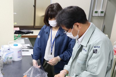 感染者が出た事業所などに出向いて採取した検体をチェックする福岡県糸島保健福祉事務所の職員。感染の急拡大で各地の保健所の業務量も増えている＝同県糸島市で2021年5月18日午前11時6分、谷由美子撮影