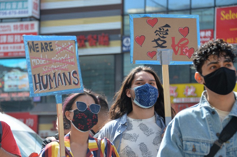 米国のアジア系住民に対する差別に抗議する集会で「私たちは模範的なマイノリティーではない。人間だ」と書かれたプラカードを掲げる人=米ニューヨークで2021年3月27日、隅俊之撮影