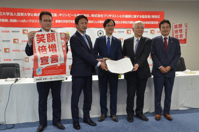 高校生による街おこし企画で産学協定を結んだ位田隆一・滋賀大学長(右から2人目)ら=滋賀県彦根市役所で、伊藤信司撮影