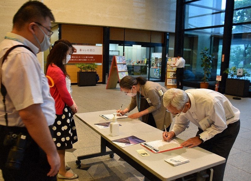 県民ホールで拉致問題の解決を求め、署名する人たち(右)