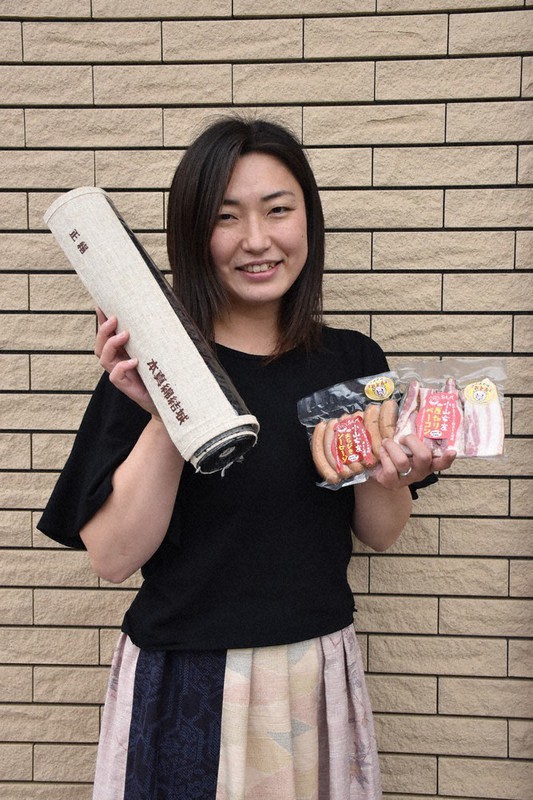 「おとん」を使ったこだわりの商品と結城紬を手に笑顔を見せる村田玲子さん=栃木県小山市で2021年5月13日、鴨田玲奈撮影