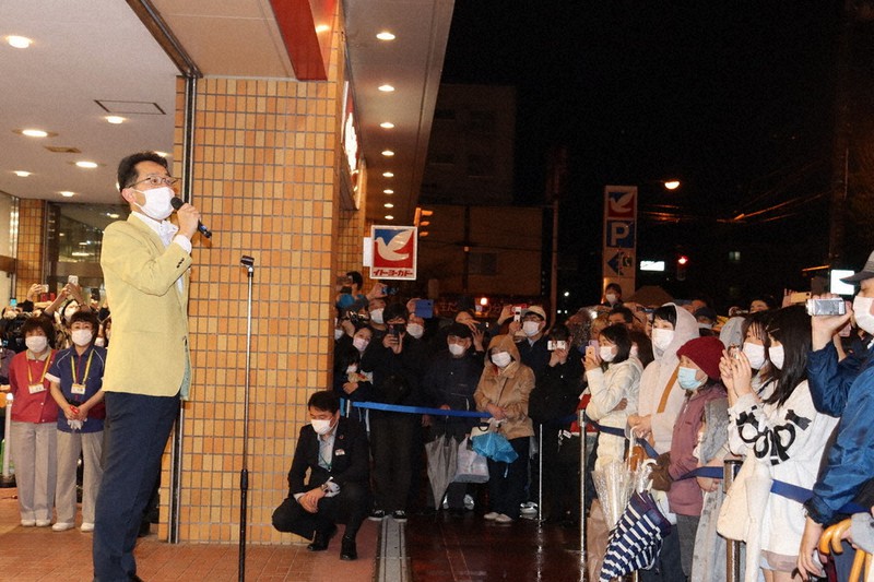 雨の中集まった買い物客にあいさつする金子吉弘店長=北海道旭川市で2021年5月9日、土屋信明撮影