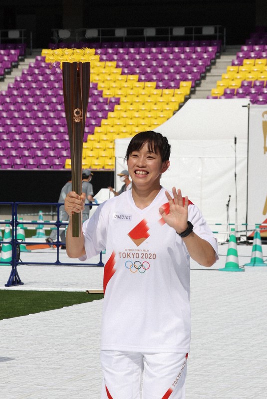 トーチを掲げ笑顔を見せる正田絢子さん=京都府亀岡市で2021年5月25日(代表撮影)