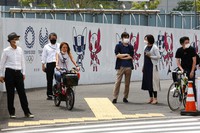 People stand by posters to promote the Tokyo Olympic Games scheduled to start in the summer of 2021, in Tokyo, on May 24, 2021. (AP Photo/Koji Sasahara)