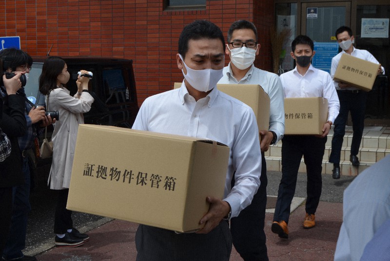 みやこ町役場から押収した証拠品を運び出す福岡県警の捜査員ら＝福岡県みやこ町で2021年5月11日午前11時20分、中里顕撮影
