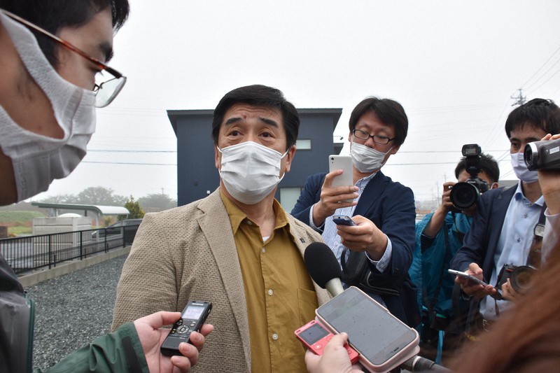 滞在先を転々とし、三重県鈴鹿市のホテル前で記者に囲まれる田中孝博容疑者。この2日後、静岡県伊豆市のホテルで逮捕される=三重県鈴鹿市で2021年5月17日午前7時44分、高井瞳撮影