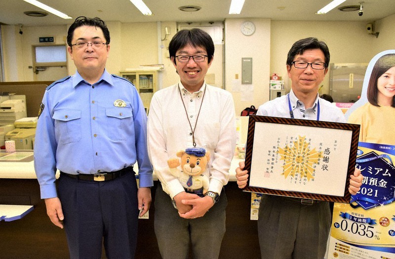熊本東署の福原幸一生活安全課長(左)から感謝状を受け取った中村さん(中央)と白石支店長
