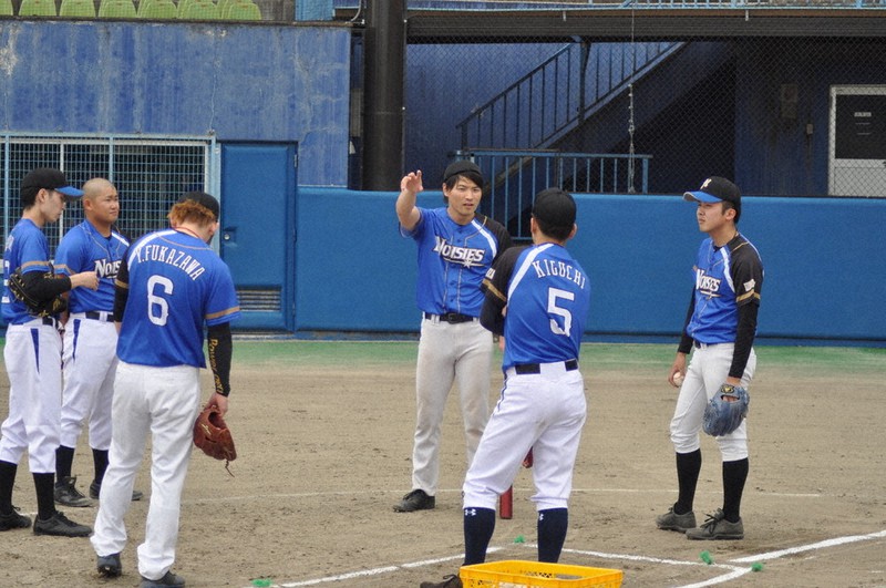 全体練習中に集まり、プレーの内容を確認し合う佐川大晟監督(右から3人目)と、泉崎ノイジーズの選手たち=福島県泉崎村さつき公園第1野球場で2021年5月29日、熊田明裕撮影