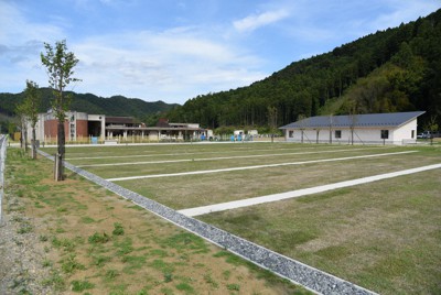 整備工事がほぼ完了し、震災遺構として公開が近づく大川小の被災校舎（左側）と新設された「大川震災伝承館」（右側）＝宮城県石巻市釜谷で2021年5月31日午後3時28分、百武信幸撮影