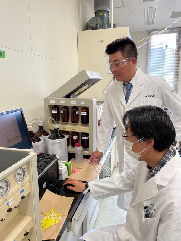 核酸医薬を研究する「ボナック」の林宏剛社長(奥)と研究員。新型コロナの新薬開発を目指す=同社提供