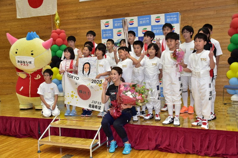 佐藤希望選手(中央)と記念撮影する激励の色紙を送った地元の子どもたち=福井県越前市で、横見知佳撮影