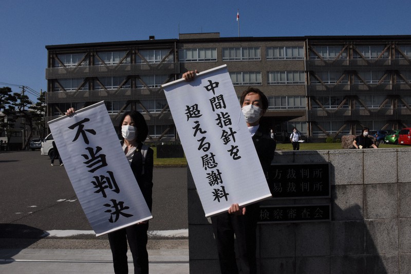 判決後に幕を掲げる原告の弁護士=新潟市中央区の新潟地裁で2021年6月2日午後3時11分、池田真由香撮影