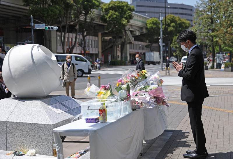 慰霊碑に向かって手を合わせる松永拓也さん=東京都豊島区で2021年4月19日午後0時17分、小川昌宏撮影