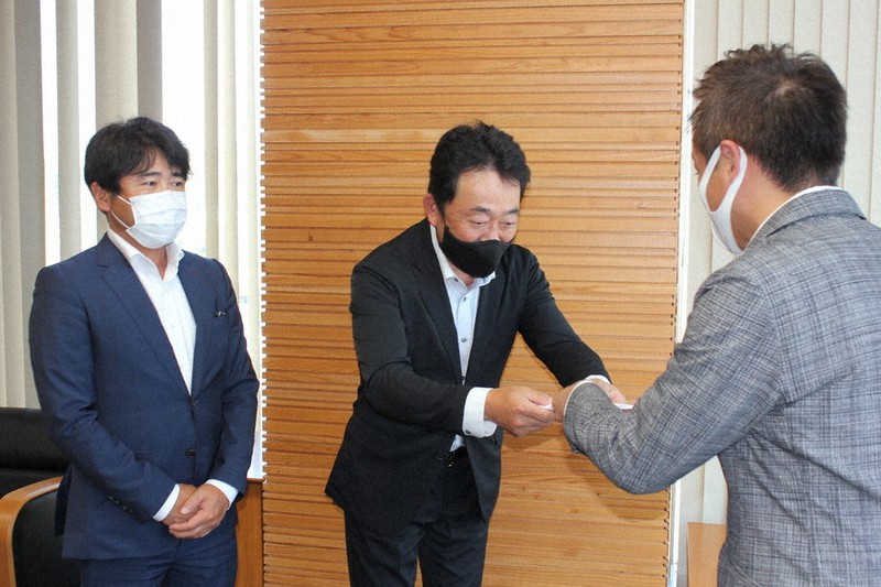 前田市長(右)に目録を手渡す中村社長(中央)