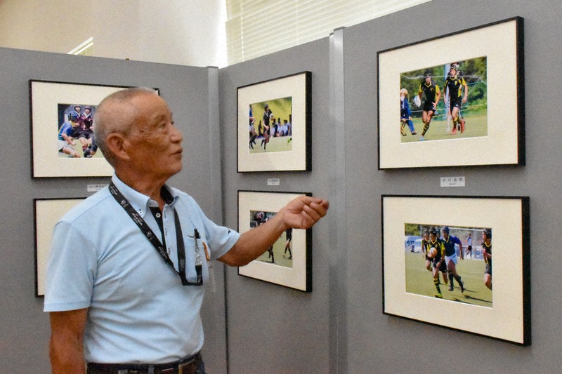 白熱した試合の写真を前に「ぜひラグビーの楽しさを知ってほしい」と語る松岡さん