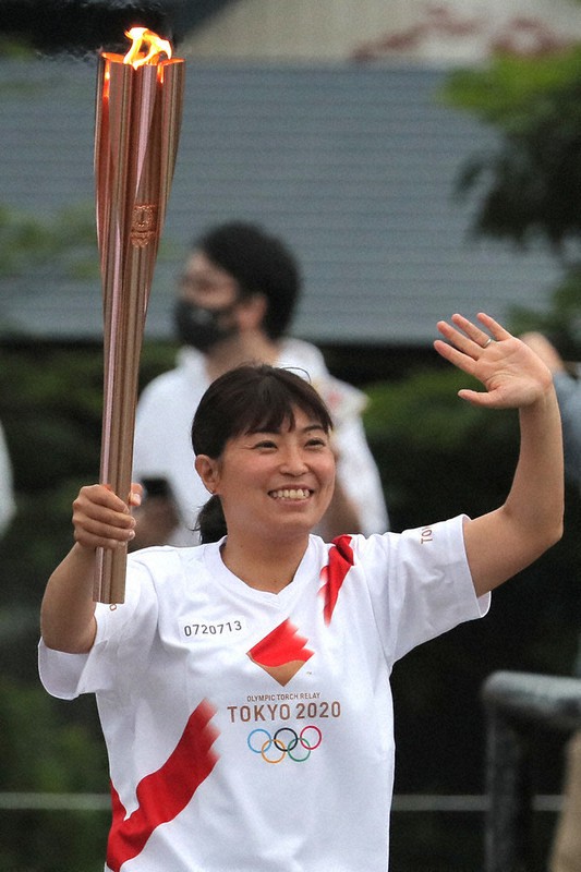 手を振りながら走る菊地利佳さん=秋田県仙北市で8日、和田大典撮影