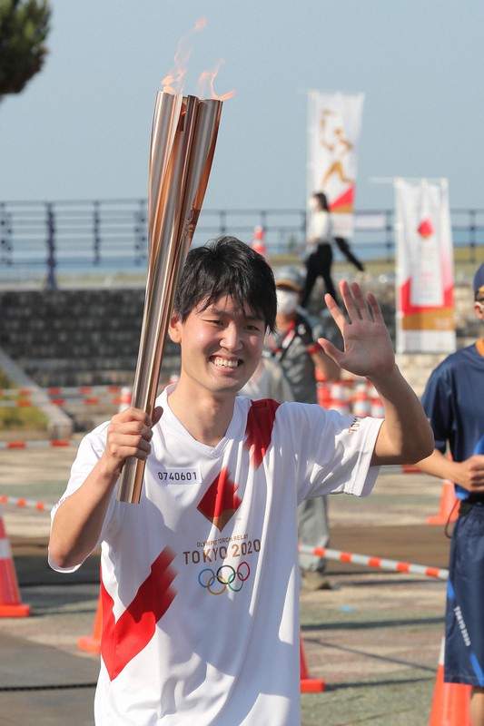 東京オリンピック聖火リレーのトーチを手に走る中村蒼太さん=青森市で2021年6月10日午後4時1分、和田大典撮影