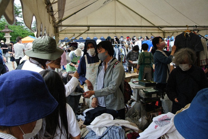 母国のためにバザーを手伝うミャンマー人留学生(中央)=富山市磯部町1の県護国神社で、青山郁子撮影