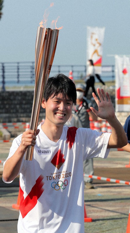 東京オリンピック聖火リレーのトーチを手に走る中村蒼太さん=青森市で10日午後4時1分、和田大典撮影