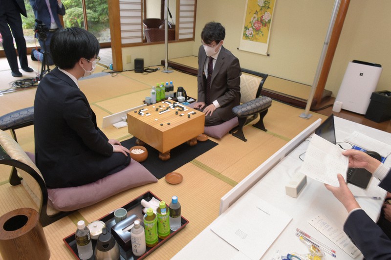 封じ手(右手前)が読み上げられ、2日目の対局が始まった。写真中央が本因坊文裕、左が挑戦者の芝野虎丸王座=北九州市小倉北区のアートホテル小倉ニュータガワで2021年6月11日午前9時4分、上入来尚撮影